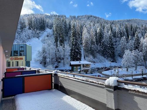 a balcony with snow covered trees and a mountain at Maison Eglantine in Mezzana