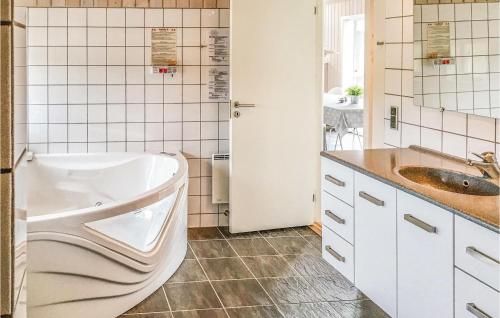 a bathroom with a tub and a sink at Nice Home In Haderslev With 3 Bedrooms And Wifi in Årøsund