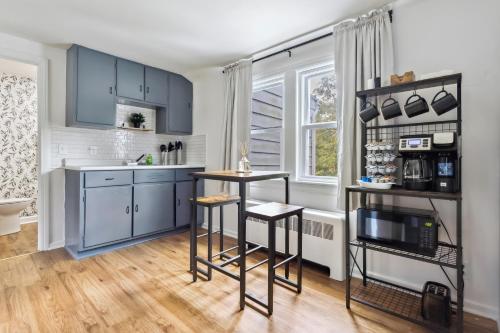 a kitchen with blue cabinets and two bar stools at Large Private Studio Apartment in Lockport