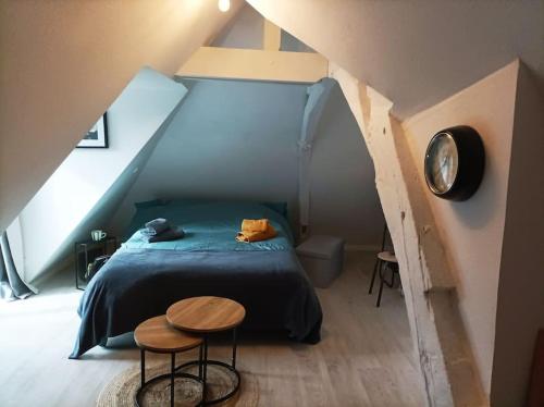 a bedroom with a bed and two tables in a attic at Studio cosy Piscine Rocherfort en Terre Centre in Rochefort-en-Terre