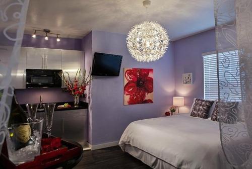 a purple bedroom with a bed and a chandelier at M HOTEL in Miami Beach