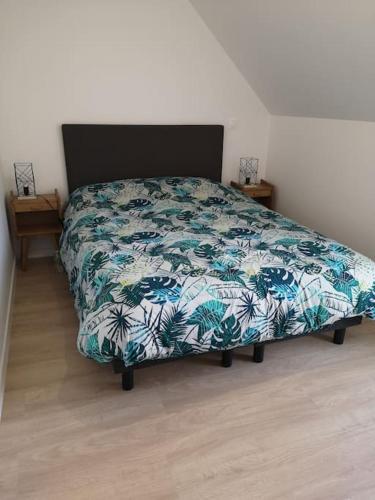 - une chambre avec un lit et une couette verte et blanche dans l'établissement Maison Jasmin-Citrus, à Saint-Valery-sur-Somme