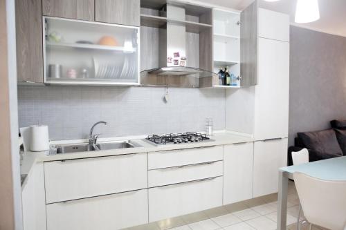 a kitchen with white cabinets and a sink at unica affittacamere in Rome