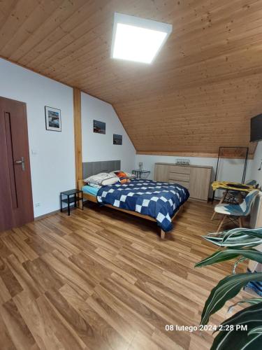 a bedroom with a bed and a wooden floor at Kapitański Dworek in Krynica Morska