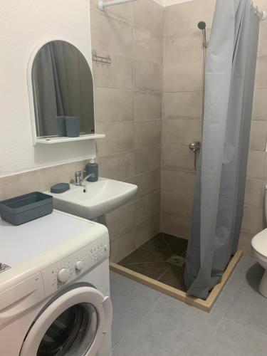 a bathroom with a washing machine and a shower at Mariyka Apartaments 2 in Sutomore