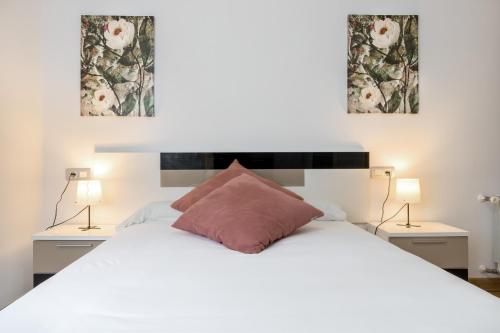 a bedroom with a white bed with two lamps at Rio Nalón in Pravia