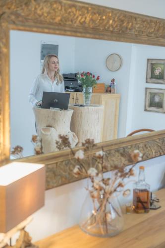 a woman is looking at her reflection in a mirror at Konak Lecic in TrÅ¡iÄ‡
