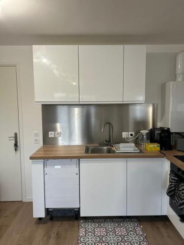 een keuken met witte kasten en een wastafel bij 2 bedrooms proche Paris/CDG/Bourget/Parc des expo in Le Blanc-Mesnil