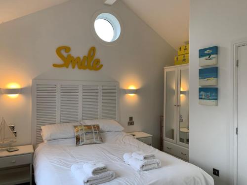 a bedroom with a white bed with towels on it at Sand Dollar at The Bay, sleeps 4, 2 small dogs welcome for free in Filey