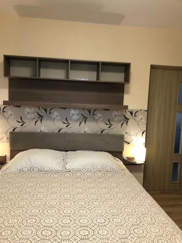 a bedroom with a white bed with a wall at Apartament Confortabil, Luminos in Galaţi