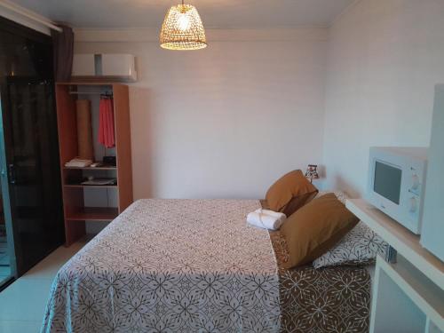 - une petite chambre avec un lit et une télévision dans l'établissement CHEZ KIKI & MIMI, 