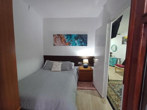 een slaapkamer met een bed en een schilderij aan de muur bij Apartamento en el casco viejo de Castro Urdiales in Castro-Urdiales