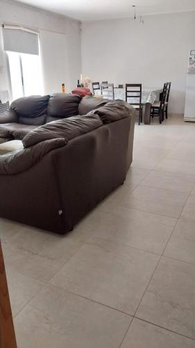 Sofá marrón en la sala de estar en Casa con pileta Matheu en Junín