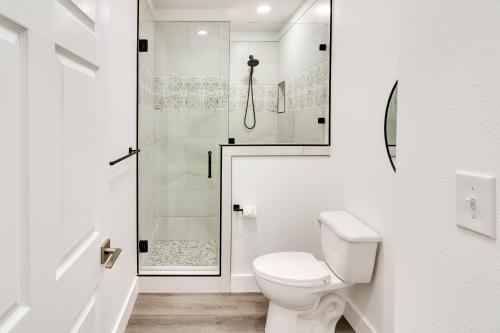 a white bathroom with a toilet and a shower at Serene Buffalo Gap Oasis on 4 Secluded Acres! in Abilene
