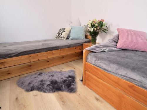 a bedroom with two beds and a fuzzy rug at Apartment Captain's Terrace in Unter Göhren