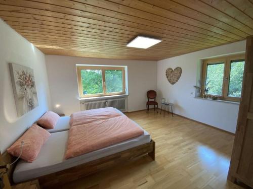 a bedroom with a large bed and two windows at Appealing apartment near lake in Argenbühl