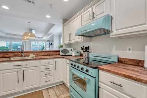a kitchen with white cabinets and blue appliances at Beach Front Condo w/Pool, Restaurant, and Bar in Tybee Island