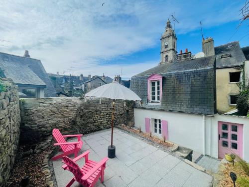 une terrasse avec des chaises roses et un parasol dans l'établissement Ty Bonbon, petit cocon avec jardin hyper centre, à Vannes