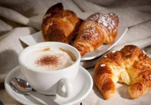 two plates of pastries and a cup of coffee and croissants at Martinirooms in Altamura
