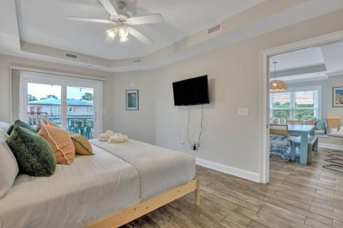 a bedroom with a bed and a flat screen tv at Beach Front Condo w/Pool, Restaurant, and Bar in Tybee Island