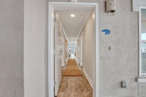 a hallway with white walls and a wooden floor at Beach Front Condo w/Pool, Restaurant, and Bar in Tybee Island