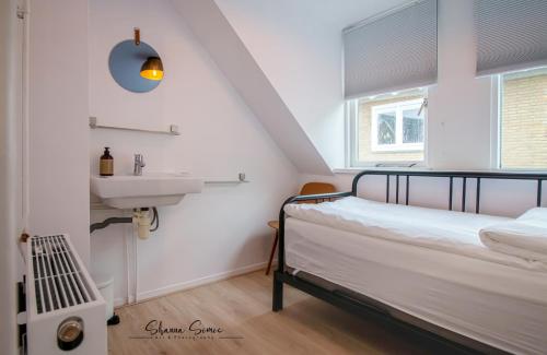 een slaapkamer met een bed en een wastafel bij Carpe Diem Egmond aan Zee by Urban Home Stay in Egmond aan Zee