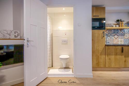een witte badkamer met een toilet in een kamer bij Carpe Diem Egmond aan Zee by Urban Home Stay in Egmond aan Zee