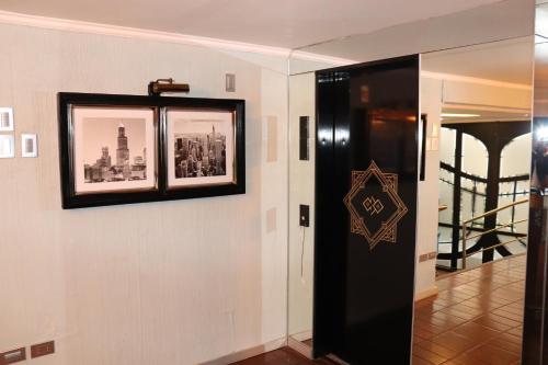 a hallway with a black door and a picture on a wall at HOTEL ALONSO DE ERCILLA in Concepción