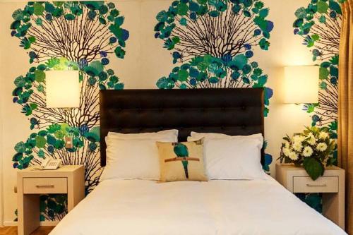 a bedroom with a bed with two night stands and flowers at HOTEL ALONSO DE ERCILLA in Concepción