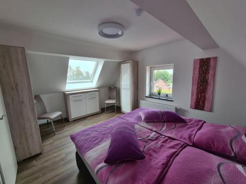 1 dormitorio con 1 cama de color púrpura y 2 ventanas en Holiday oasis mints en Cuxhaven