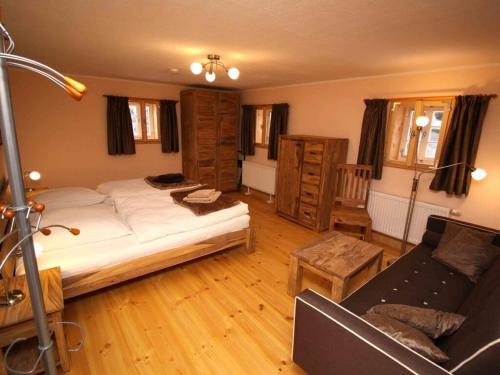 um quarto com uma cama grande e um sofá em Holiday home Goßdorf em Hohnstein