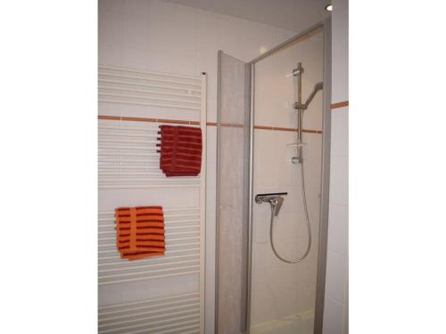 La salle de bains est pourvue d'une douche et de serviettes orange sur la porte. dans l'établissement Holiday apartment seagull, à Zinnowitz