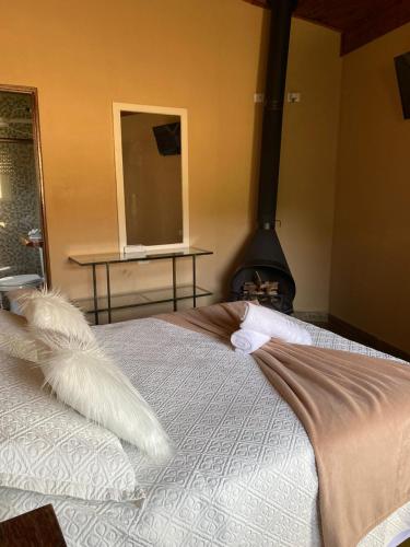 a bedroom with a bed with two white feathers on it at Pousada Refugio Sol e Brisa in São Bento do Sapucaí