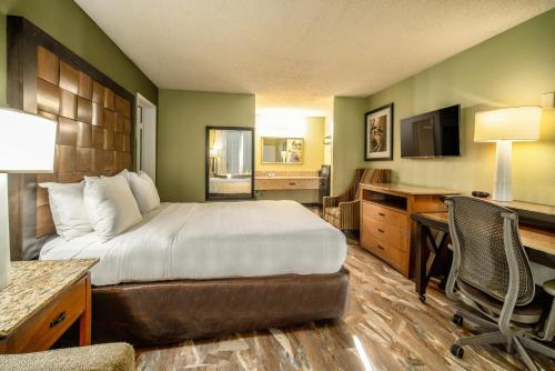 a hotel room with a bed and a desk at The Buena Park Hotel & Suites in Buena Park