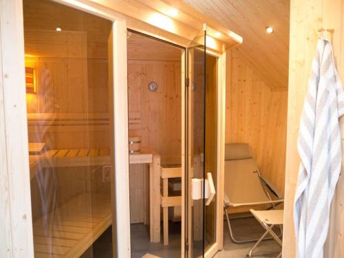 uma sauna com uma porta de vidro num quarto em Holiday home Falkenweg em Holm Seppensen