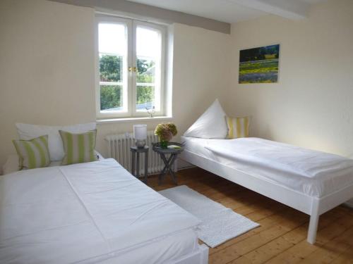 2 camas blancas en una habitación con ventana en Holiday home Rike, en Emmelsbüll-Horsbüll