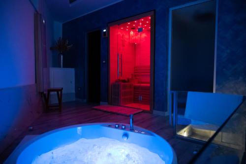 una vasca da bagno in una stanza con luce rossa di AETERNA SUITES SPA Apartment a Terracina
