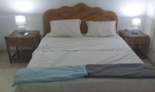 - un grand lit avec 2 tables de chevet et 2 lampes dans l'établissement Apartamento de 2 pisos en Porlamar, à Porlamar