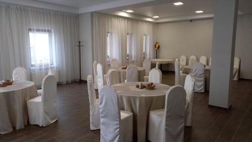 a room full of tables and chairs with white table cloths at Pensiunea turistică MUZE in Rezina