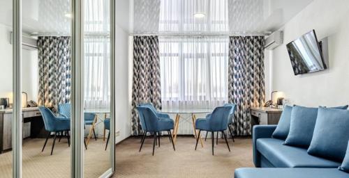 a living room with a blue couch and a table and chairs at SPA Hotel Galera in Kyiv