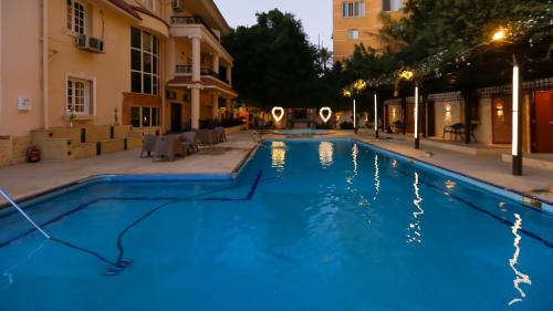 a swimming pool in front of a building at night at Turquoise Pyramids Palace in Giza