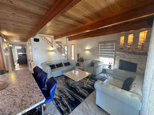 ein Wohnzimmer mit weißen Sofas und einem Tisch in der Unterkunft Blue House in Sylvan Lake