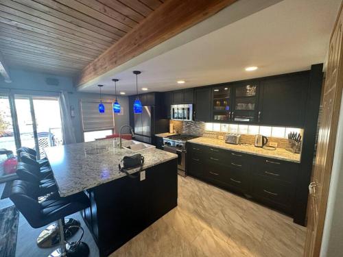 a kitchen with black cabinets and a counter top at Blue House in Sylvan Lake