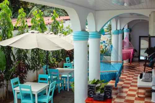 a patio with blue chairs and an umbrella at Hostal Eden in Moyogalpa