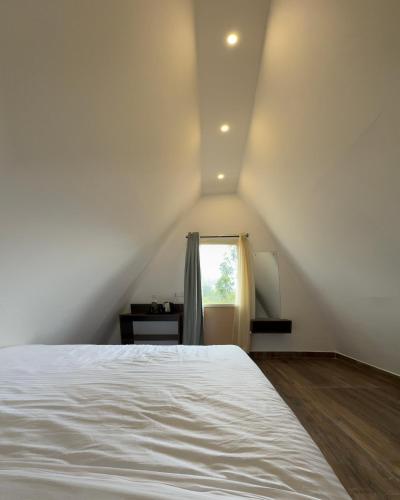 a bedroom with a white bed and a window at EUCALIA GLAMPS- VATTAVADA in Vattavada