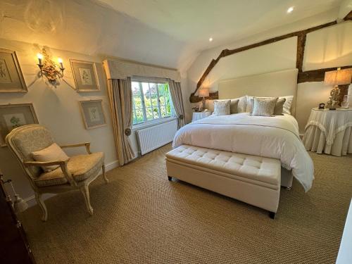 um quarto com uma cama grande e uma cadeira em Well house em Stone