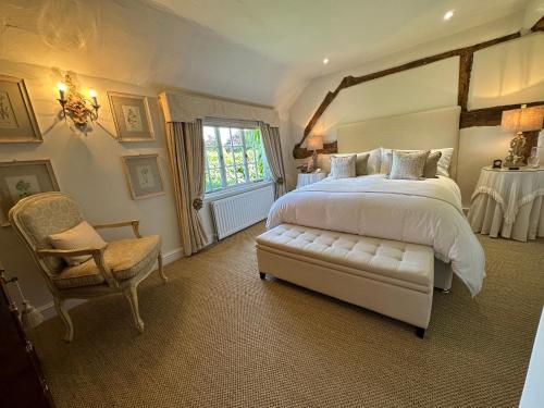 a bedroom with a large bed and a chair at Well house in Stone