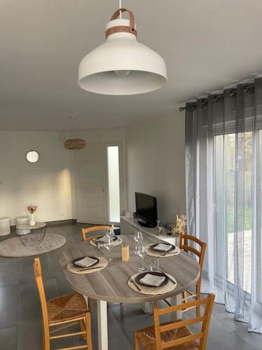 - une salle à manger avec une table et des chaises en bois dans l'établissement Maison centre ville Ploërmel avec terrasse, à Ploërmel