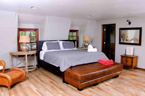 um quarto com uma cama grande e uma cadeira em The Lodge on Gray House Farm em Hulbert
