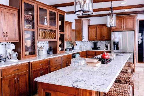uma cozinha com armários de madeira e uma bancada de mármore em The Lodge on Gray House Farm em Hulbert